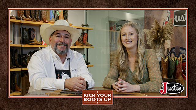 A woman and a man talking to each other, smiling at the camera.